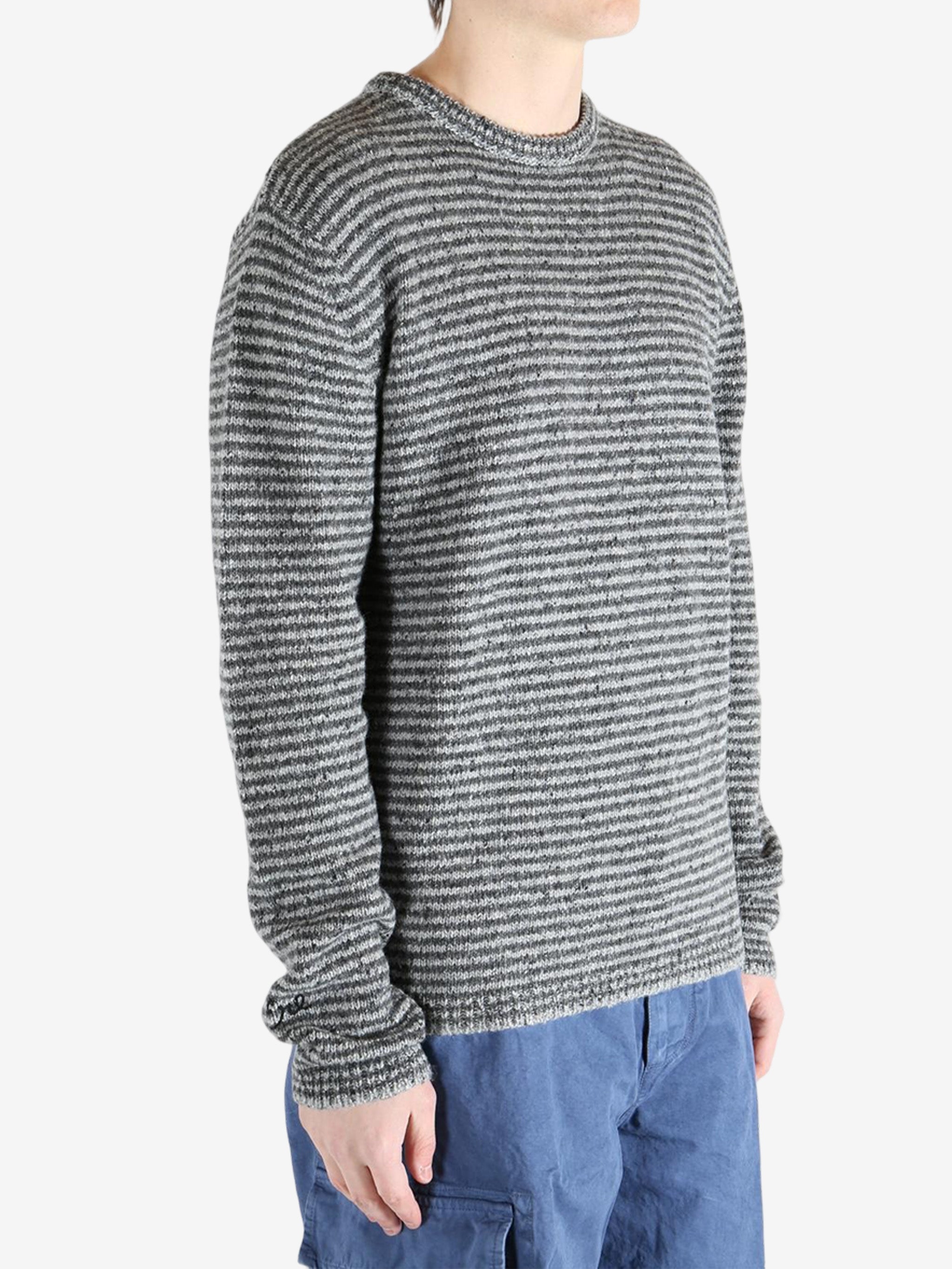 Grey knitwear worn by a person, showing the knitwear fit