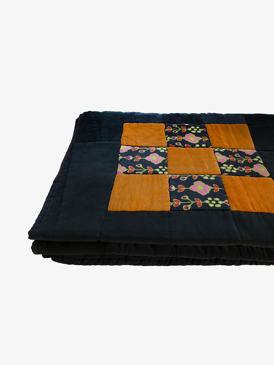 Silk patchwork quilt by Lily Raskind, folded to reveal padding and quilt thickness.