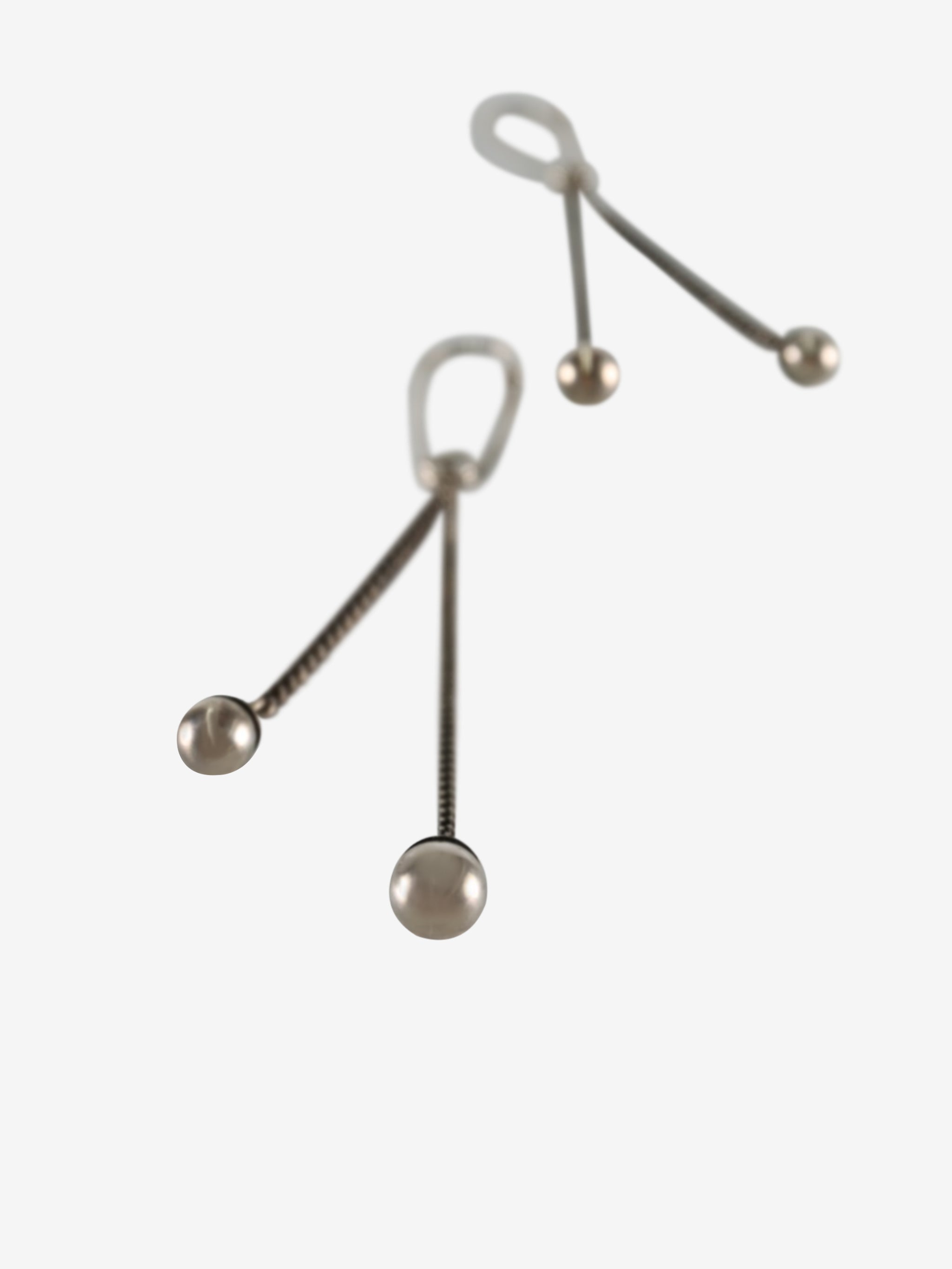 Close up of the silver earrings, showing texture of the silver fabric