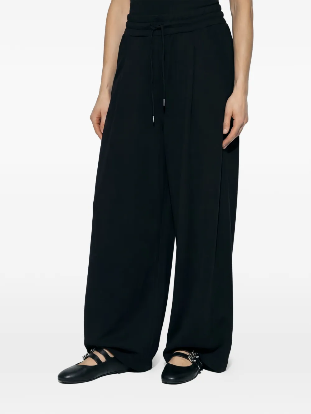 Black pants worn by a person, showing the pants fit